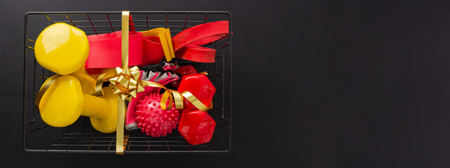 A festive set of tools for sports. Red and yellow dumbbells, fitness bands, gloves and a massage...
