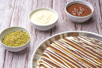 Traditional Arabian sweets with Cream and Cheese with pistachio nuts and flavor on top on gray background