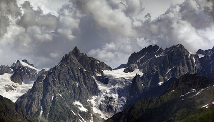 High mountains with glacier and cloudy sky at summer