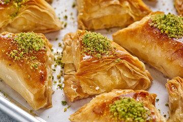 Arabian Traditional Desserts - Cream and cheeses with pistachio flavor and nuts topping on gray background