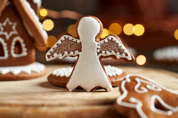 Gingerbread angel with Christmas lights and gingerbread house in the background