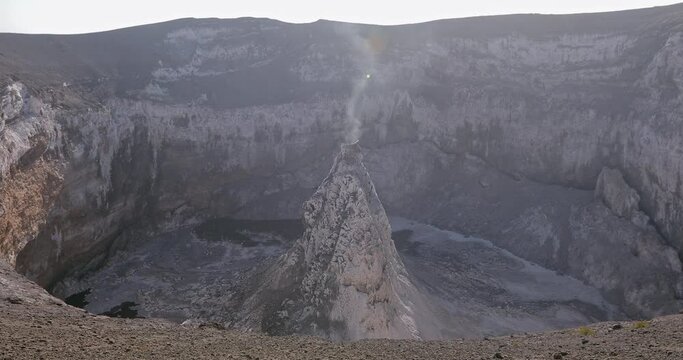 The crater of the frozen volcano Lengai in Africa. Smoke comes from the middle of the volcano.
