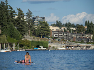 Usa, Washington State, Bellevue, Meydenbauer Bay, woman seated on stand-up paddleboard