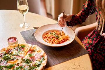 Italian pasta with tomato, meat. Close-up spaghetti Bolognese wind it around a fork with a spoon. Parmesan cheese