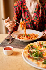 Italian pasta with tomato, meat. Close-up spaghetti Bolognese wind it around a fork with a spoon....