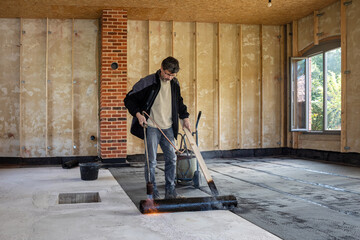 Installation of waterproofing on the concrete foundation by heating and melting rolls of bitumen...