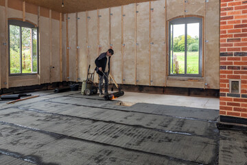 Installation of waterproofing on the concrete foundation by heating and melting rolls of bitumen...