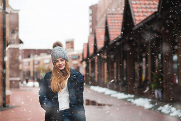 Magnificent red haired lady walking with snowflakes