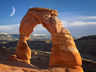 delicate arch in Arches National Park with clouds and moon