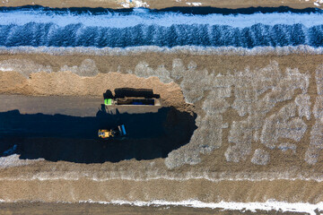 Aerial photo showing large rows of harvested sugar beets waiting to go to sugar beet factory. Drone...