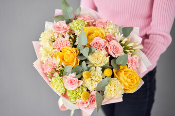 Beautiful bouquet of mixed flowers without packaging. Handsome fresh bouquet in woman hand. Small flower shop and Flowers delivery.