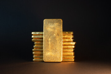 Gold bullion bars on black background. Stack of large cast investment gold ingots. Swiss gold....