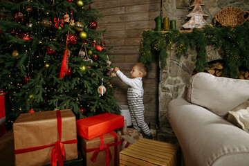 little boy playing against the background of new year decorations