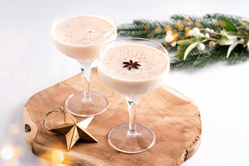 Eggnog on wooden tray, Christmas cocktail in coupe glass, top view