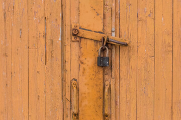 Old orange or brown wooden door with lock closed exit vintage antique background