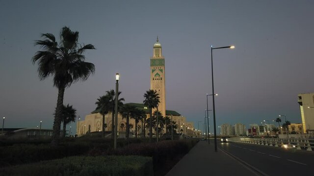 Night traffic, cars on highway road on sunset evening night in busy city, urban view of Hassan II mosque in Casablanca, Morocco