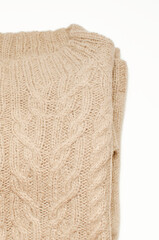 Fashionable beige knitted jumper with a beautiful pattern, close-up.