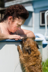 Female. on the edge of the pool, communicating with the dog