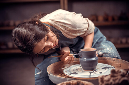 Hands of the master potter and vase of clay on the potter's wheel close-up. Master crock. Twisted potter's wheel.