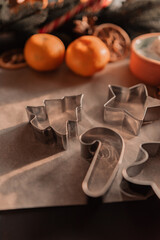 Baking dishes for Christmas homemade cookies on parchment. background for the new year 2022. attributes of the new year: tangerines, cones, tree