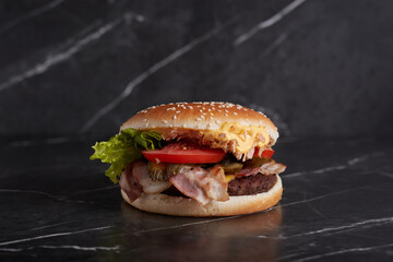 burger with meat and cheese on the table, american cuisine, close-up, tomato, dark background, marble,