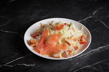 asian salad with meat and seafood, shrimp, plate close-up on a dark background