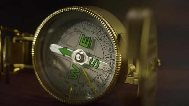 Gold compass close-up, golden compass on table. Traveling and tourism concept, navigation.