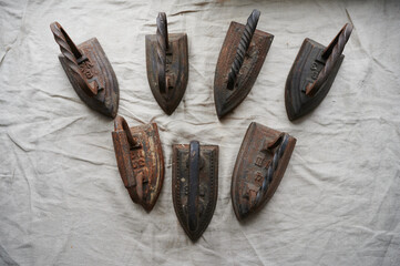 conceptual photography - a set of antique cast iron irons on the surface of a canvas lying on a windowsill symbolizing group relationships