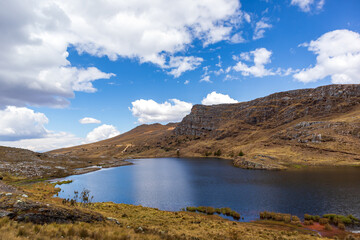 Fototapeta na wymiar Wide view of the lake under the sky surrounded by an Andean ecosystem.