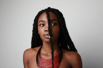 Confident black African young woman with braids, isolated.