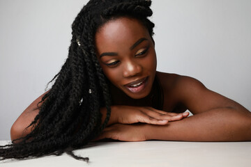 Portrait of a confident black African young woman with braids posing on white.