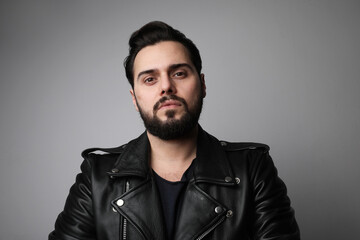 Brutal bearded young man, wearing leather jacket. Isolated.