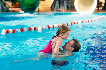 dad and daughter have fun and play in the pool. swimming training. 