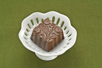 Chocolate em um prato branco em fundo verde
