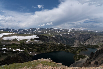 USA, Wyoming. Alpine lake, mountains with clouds and snow, Beartooth Pass.