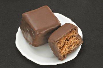 Chocolate em cima de um prato branco no fundo escuro