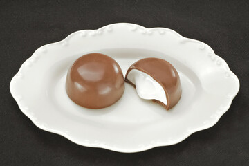 Chocolate em cima de um prato branco no fundo escuro