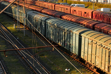 Lutsk, Ukraine - May 26,2021: Cargo train with goods wagon on rails. Roofs of locomotive with shipping container in depot. Freight train carriages at railway station. Classification or sort rail yard