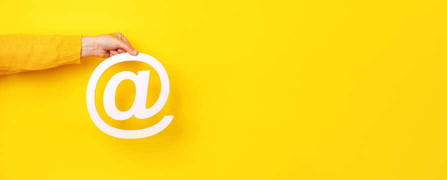 email sign in hand over yellow background, panoramic layout