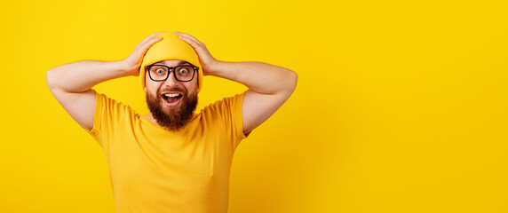 Fototapeta surprised man in glasses over yellow background, wow emotion, concept of promotions or big discounts, panoramic layout obraz