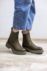 Beautiful female legs in leather boots and jeans. Female legs in fashionable boots