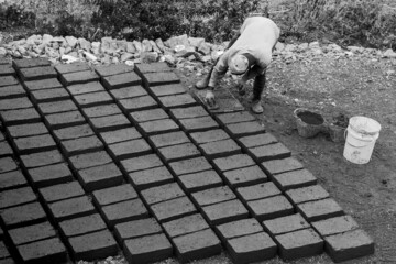 person making clay bricks