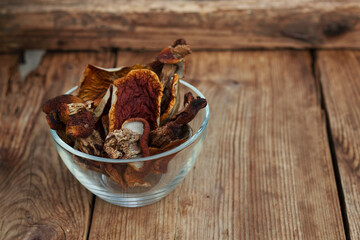 dried boletus edulis mushrooms in a bowl on the wooden table