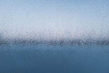 Fancy patterns drawn on a frosty winter day. Snow patterns on the glass, close-up. Frost texture...