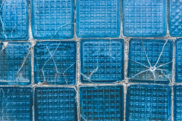 Old broken glass with cracks blue texture damaged background