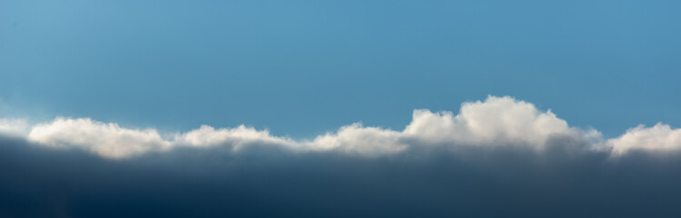 Falling clouds in the blue sky. Place for the text copy space