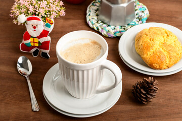a cup with cappuccino, some cookies on the side and Christmas ornaments, remembering the proximity...