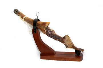 The bone of a leg of a Spanish Serrano ham, on a wooden support, a before and after concept....