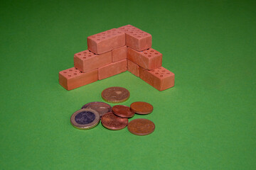 Conceptual symbol image for home financing, red bricks building a wall with several euro coins