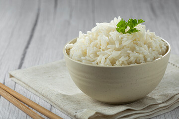 Bowl with cooked rice on the table.